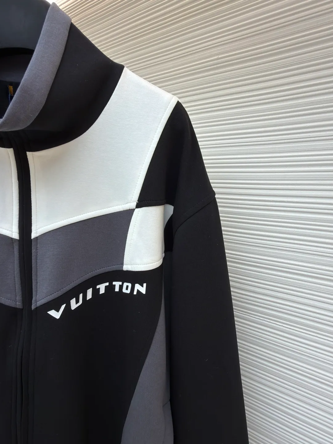 LOUIS VUITTON Spliced jogging sweatshirt long-sleeved sweatshirt ●Original version: Purchased and developed by 13126 ●Item number: 1682019-B70 ●Fabric: 100% cotton ●Technology: Made by positioning cutting machine ●Color: black, gray and white ●Version: fitted version ●Weight: about 1015 grams ●Size: S-M-L-XL ●Description: This Louis Vuitton color-blocked jacket is made of high-elastic composite knitted fabric (polyester fiber + spandex blend), which has been treated with matte brushing, giving it both stiffness and skin-friendly feel. The body of the garment adopts geometric color-blocking cutting technology: black, gray, and white pieces are spliced ​​diagonally in a V-shape, and the edges are processed by "laser seamless fit + same-color overlocking" to ensure smooth seams without any irritation. The "VUITTON" logo on the chest uses a three-dimensional silicone imprinting process. It is first laid with a low-temperature setting glue layer and then covered with a matte coating to take into account the three-dimensionality and washability of the logo. The neckline is a stand-up collar design with built-in elastic lining reinforcement; the zipper is made of brand-customized metal, and the chain teeth are the same color as the fabric; the cuffs and hem are equipped with high-elastic ribbing, and the overall shape is ergonomically optimized to suit daily casual scenes. The overall wiring is straight and delicate, the fabric is comfortable and soft, and the color is consistent without color difference. It can be matched with the same style to create a fashionable look and control various occasions. Customized accessories, complete with three standards, same style for men and women!